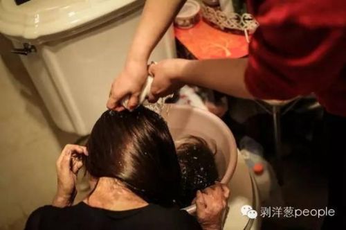 周岩在母亲的帮助下洗头。新京报记者彭子洋摄