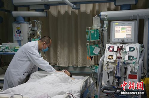 2017年1月27日，滨州医学院附属医院急诊科重症监护室医生在给患者做检查。中新网邱宇摄