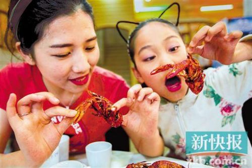 游客在“龙虾之乡”江苏省盱眙县一饭店品尝小龙虾。新华社发